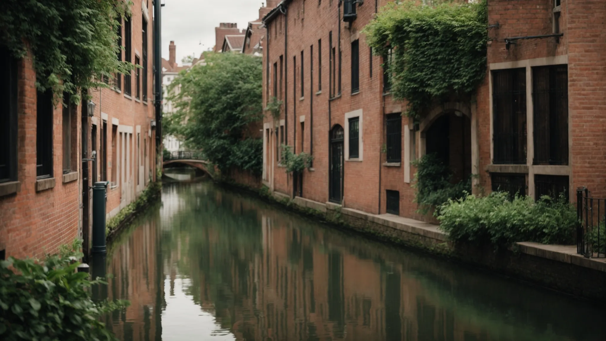 in the heart of the city, a serene canal bordered by lush greenery and historic brick buildings offers a picturesque escape from urban hustle.