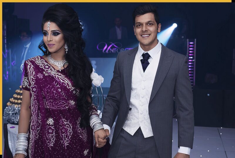 Bride in a purple embellished outfit holding hands with the groom at their reception