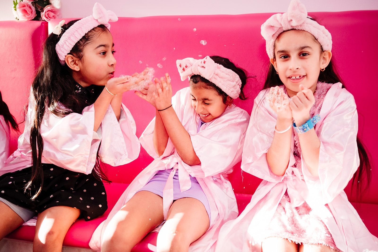 Three girls enjoying a pink-themed birthday celebration