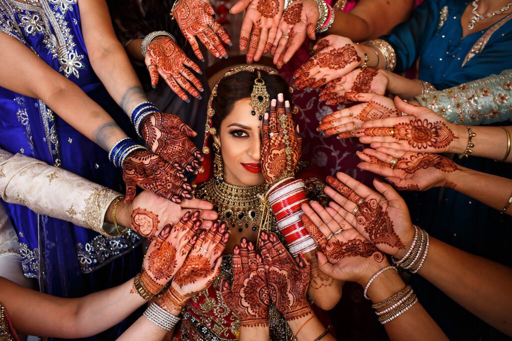 Mehndi-decorated hands surrounding the bride before her wedding celebrations