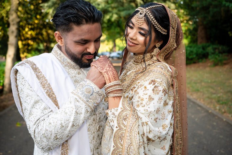 Bride and groom in cream wedding attire posing together outdoors