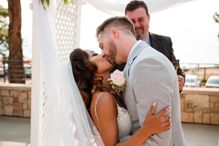 Newly married couple sharing their first kiss at an outdoor ceremony