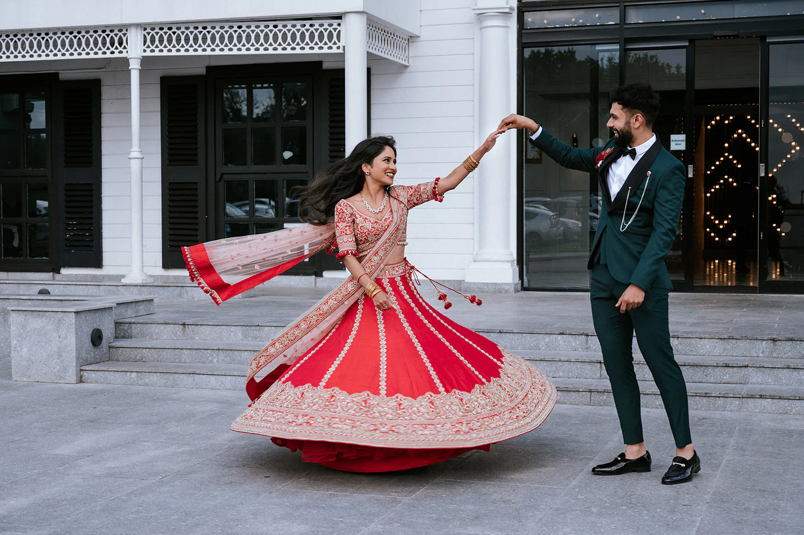Asian wedding couple dancing together outside their reception venue