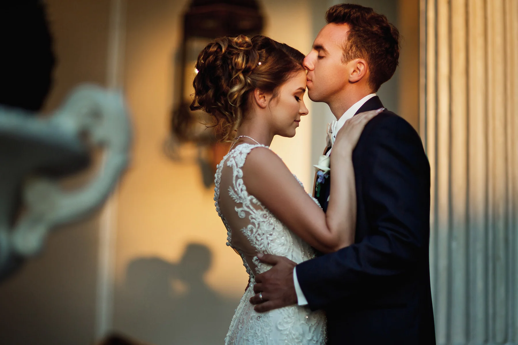 Groom kissing the bride during a warm golden-hour wedding portrait