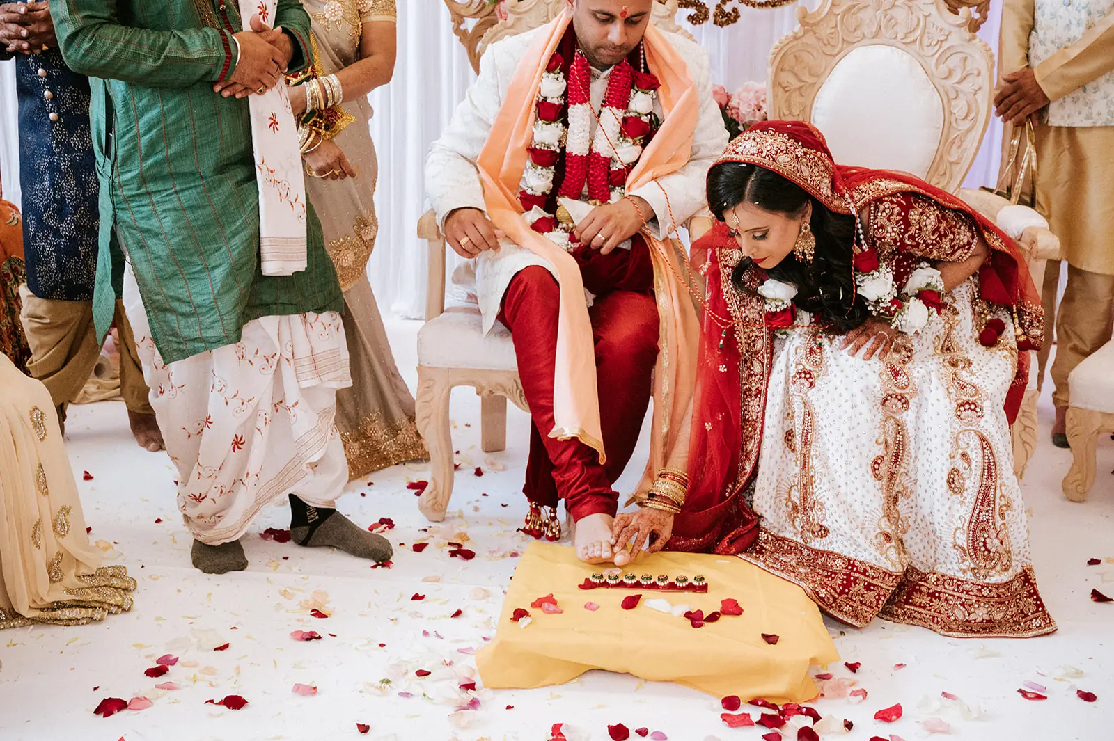 Bride and groom taking part in a wedding ritual surrounded by family