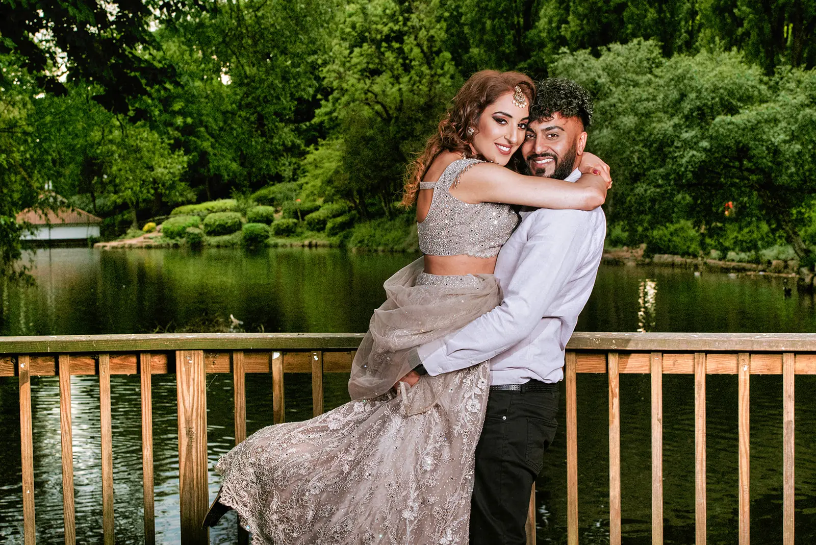 Engaged couple embracing beside a lake during their portrait session
