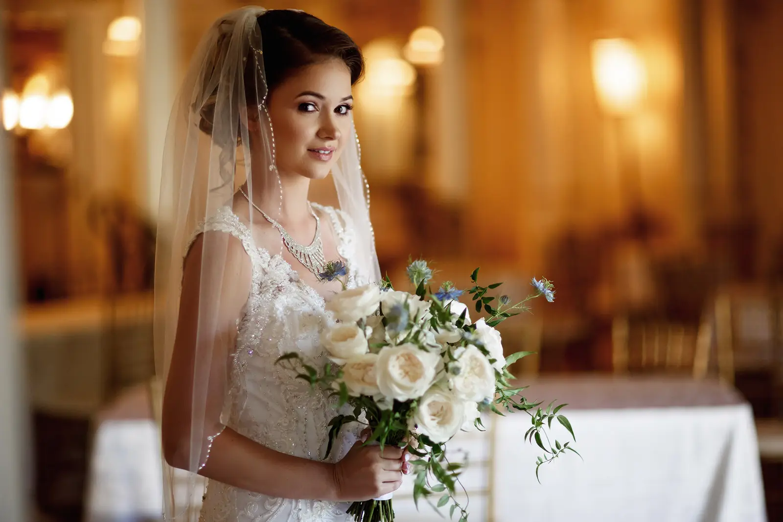 Bride holding a white bouquet indoors