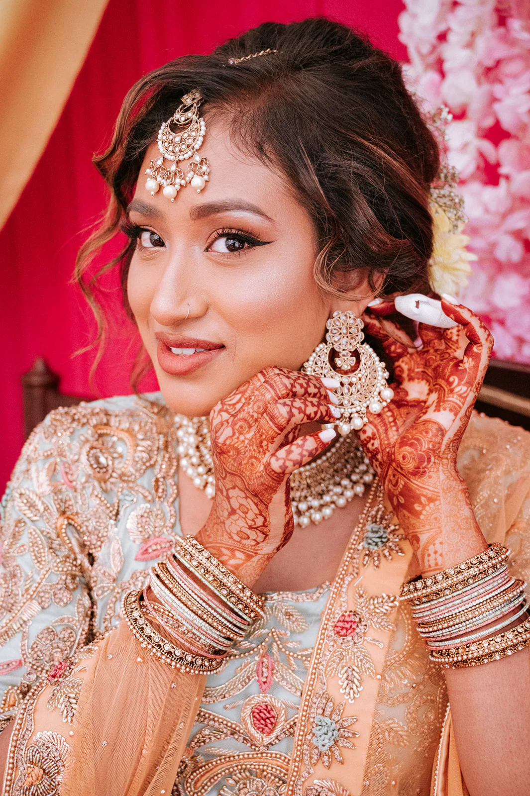 Hindu bride adjusting her wedding jewellery during morning preparations