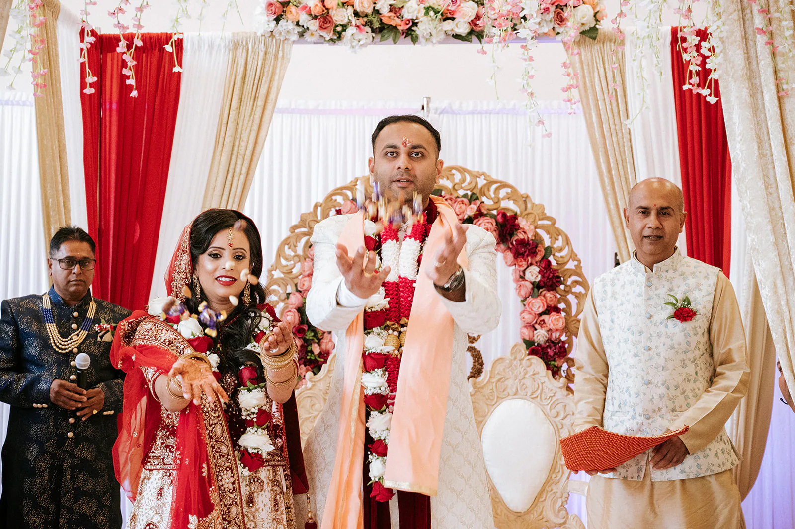 Hindu bride and groom exchanging flower garlands during their Birmingham ceremony