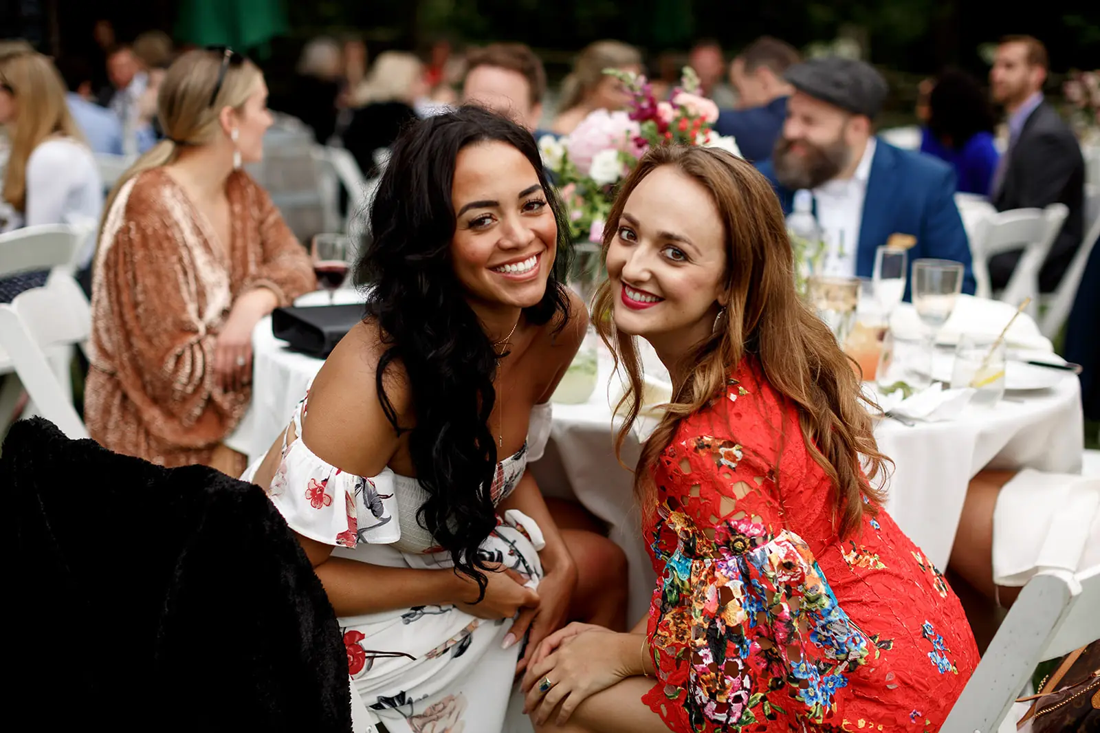 Wedding guests smiling together during an outdoor reception
