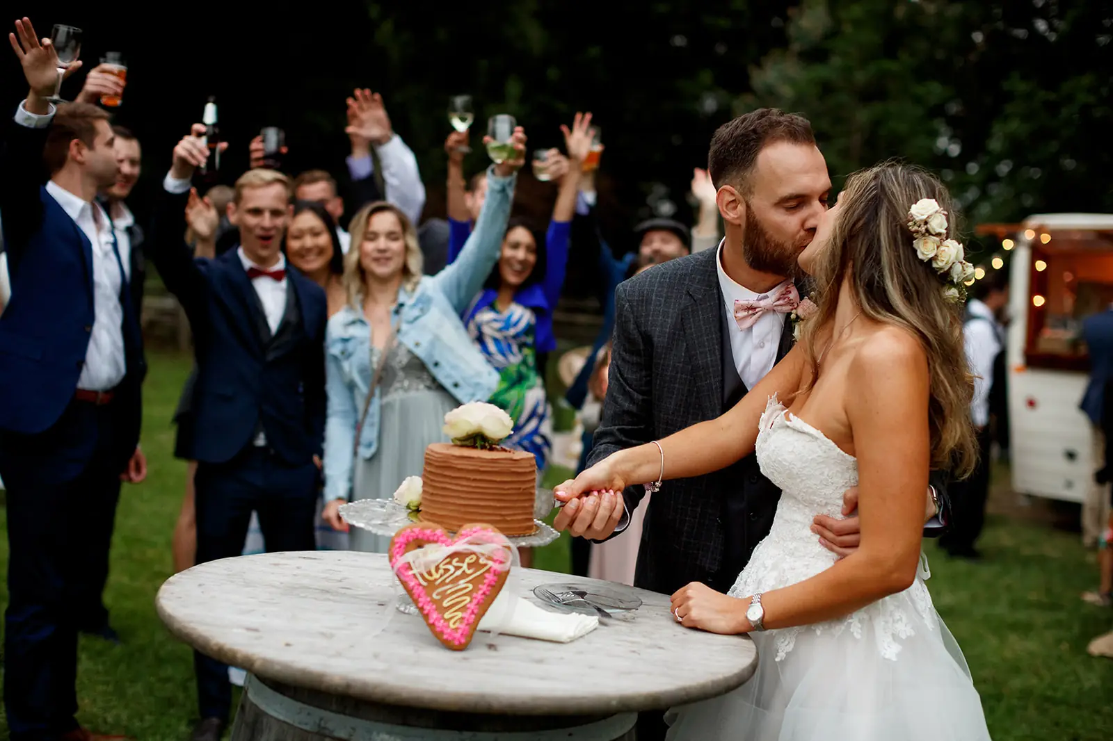 Bride and groom cutting their wedding cake as guests celebrate