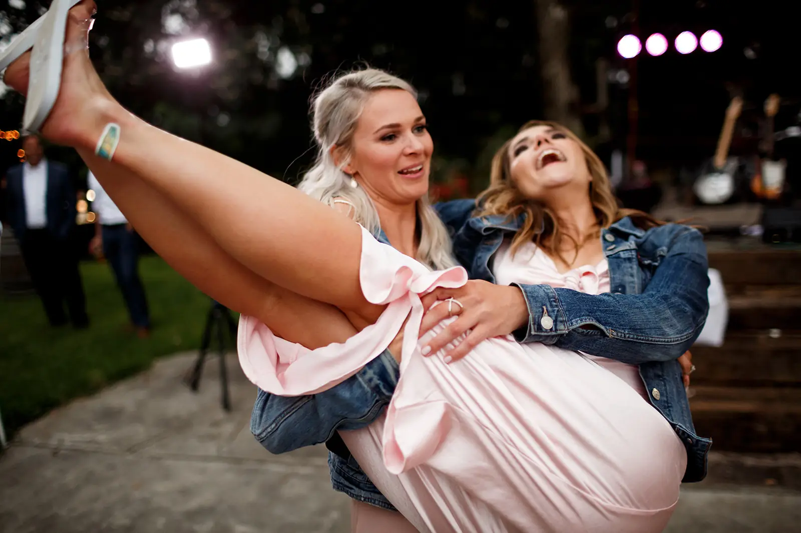 Friends sharing a playful moment on the wedding dance floor