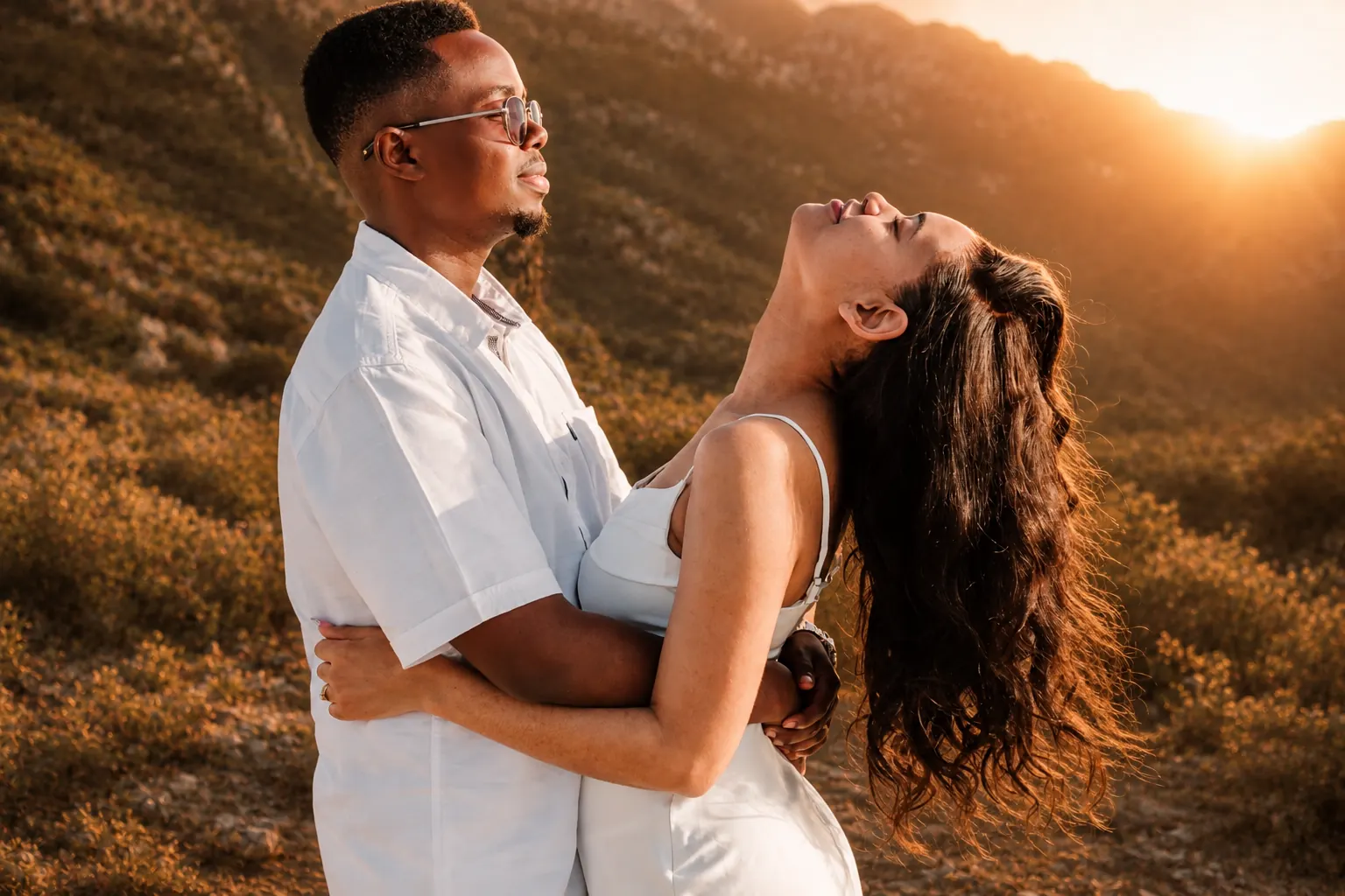 Couple embracing in warm evening light during an engagement portrait session