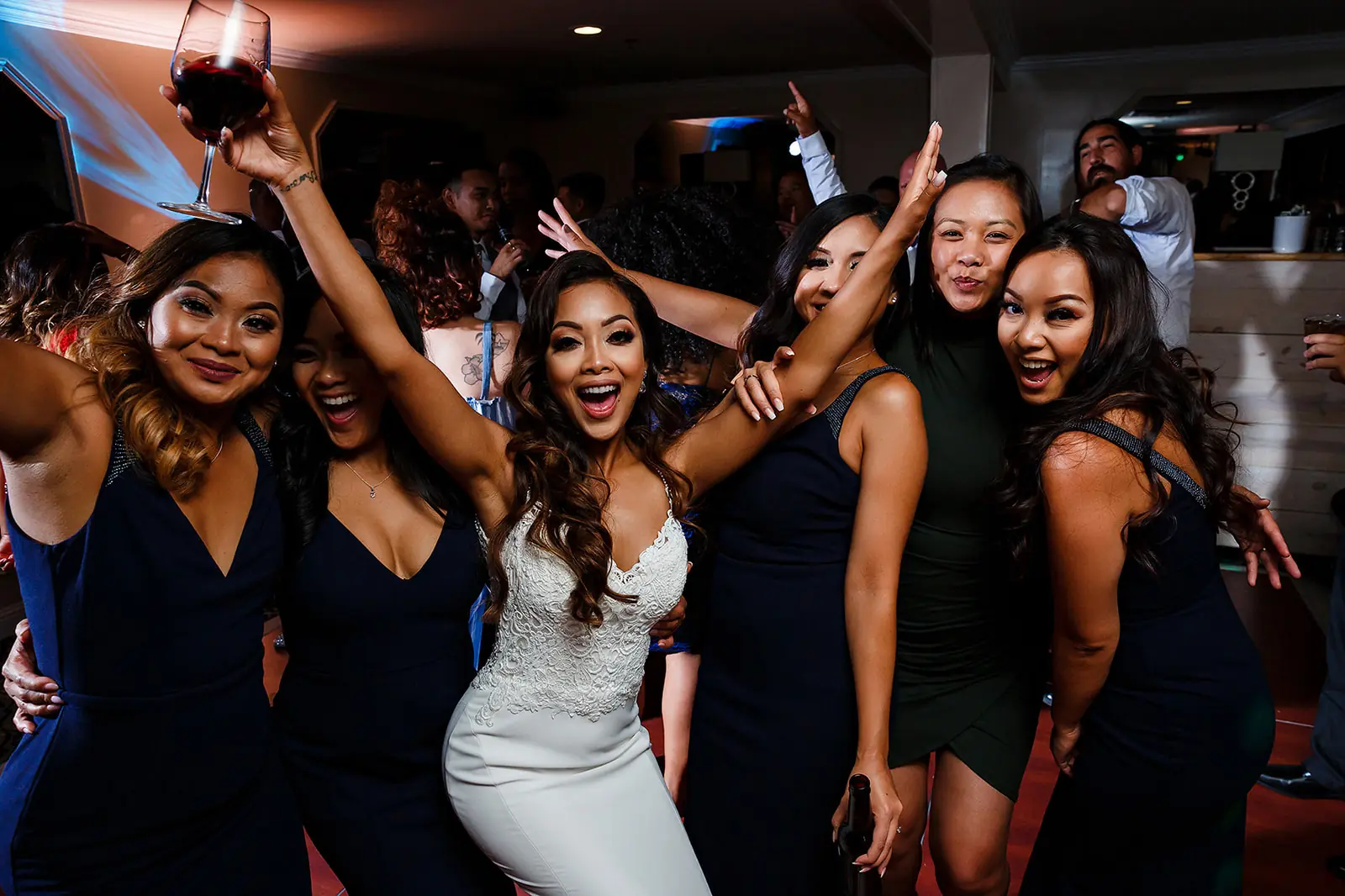 Bride celebrating on the dance floor with friends