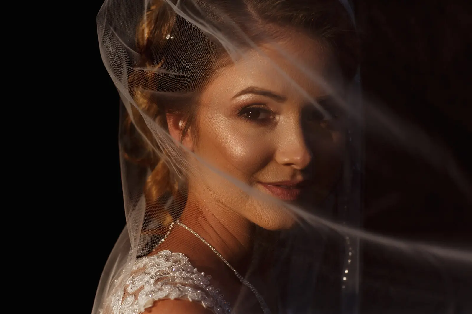 Close-up bridal portrait beneath a delicate wedding veil