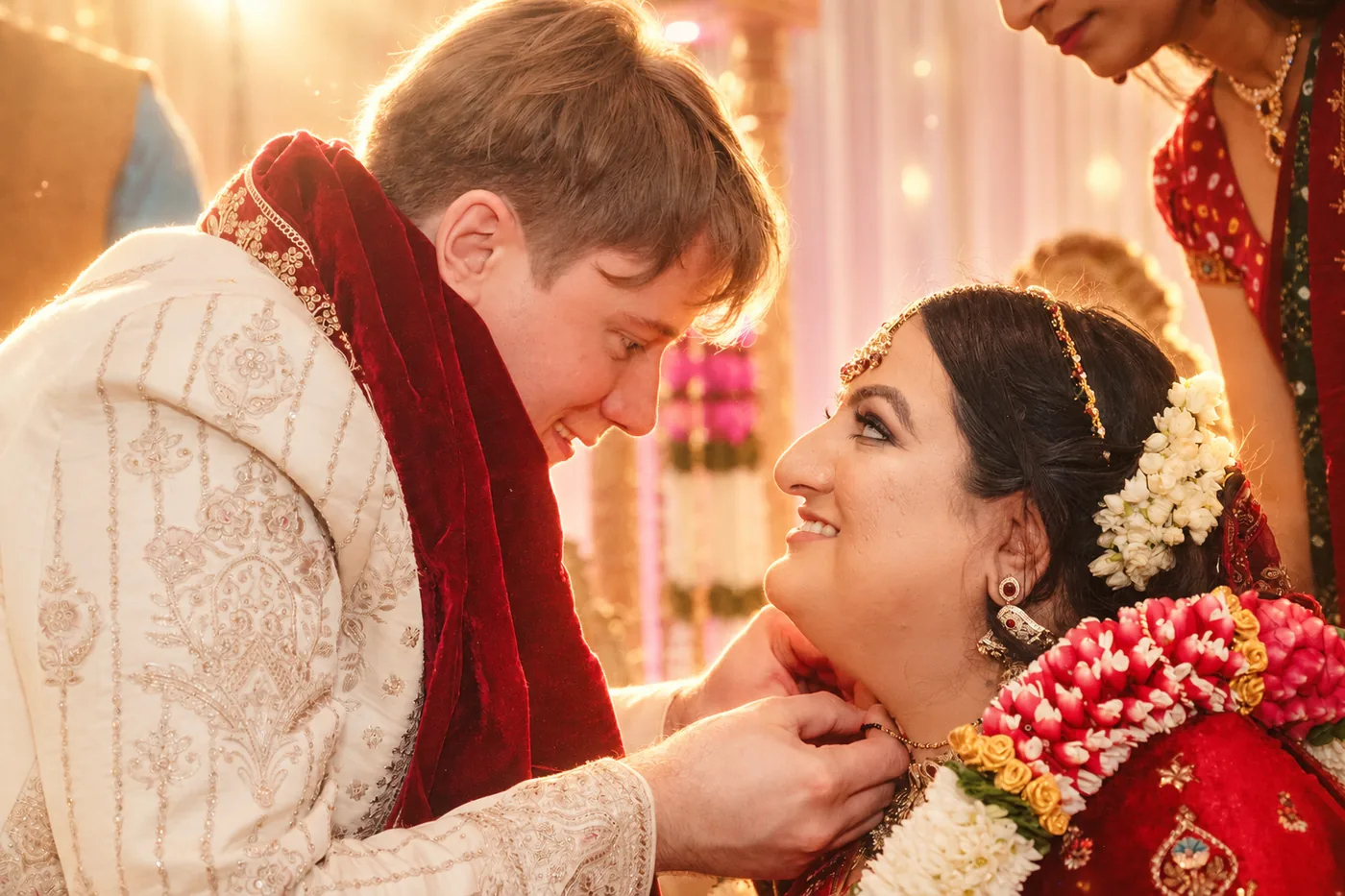 Groom fastening the mangalsutra around the bride's neck during a Hindu wedding ceremony in Birmingham