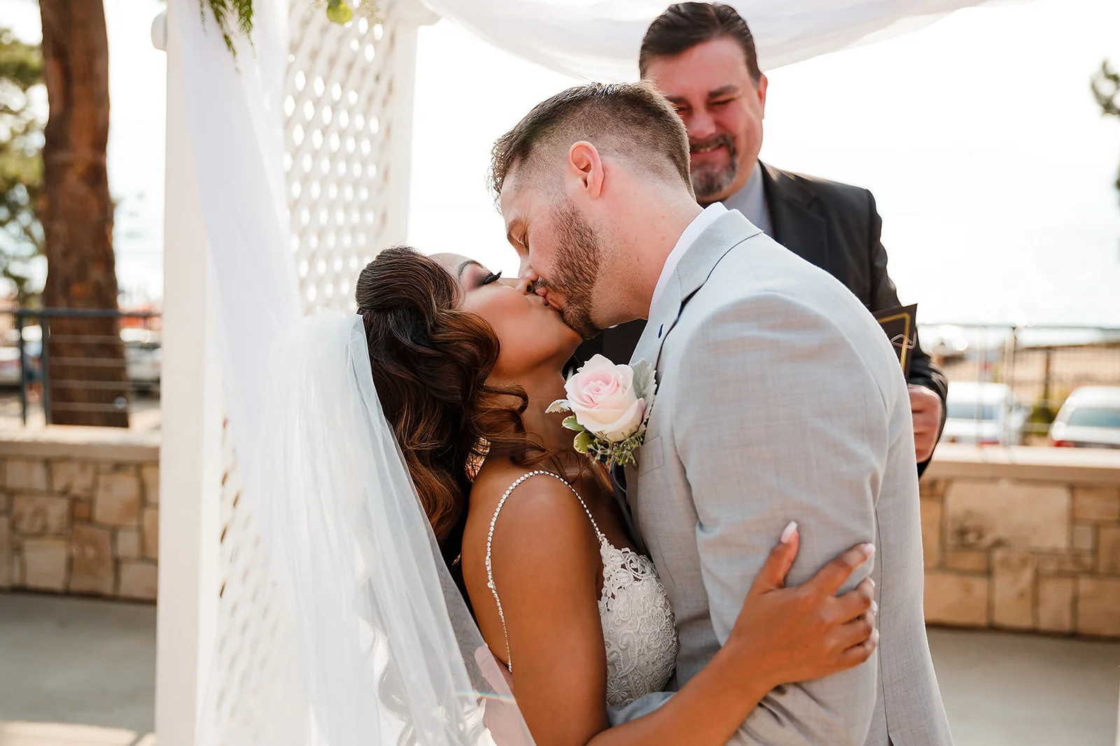 Newlyweds sharing their first kiss during an outdoor ceremony