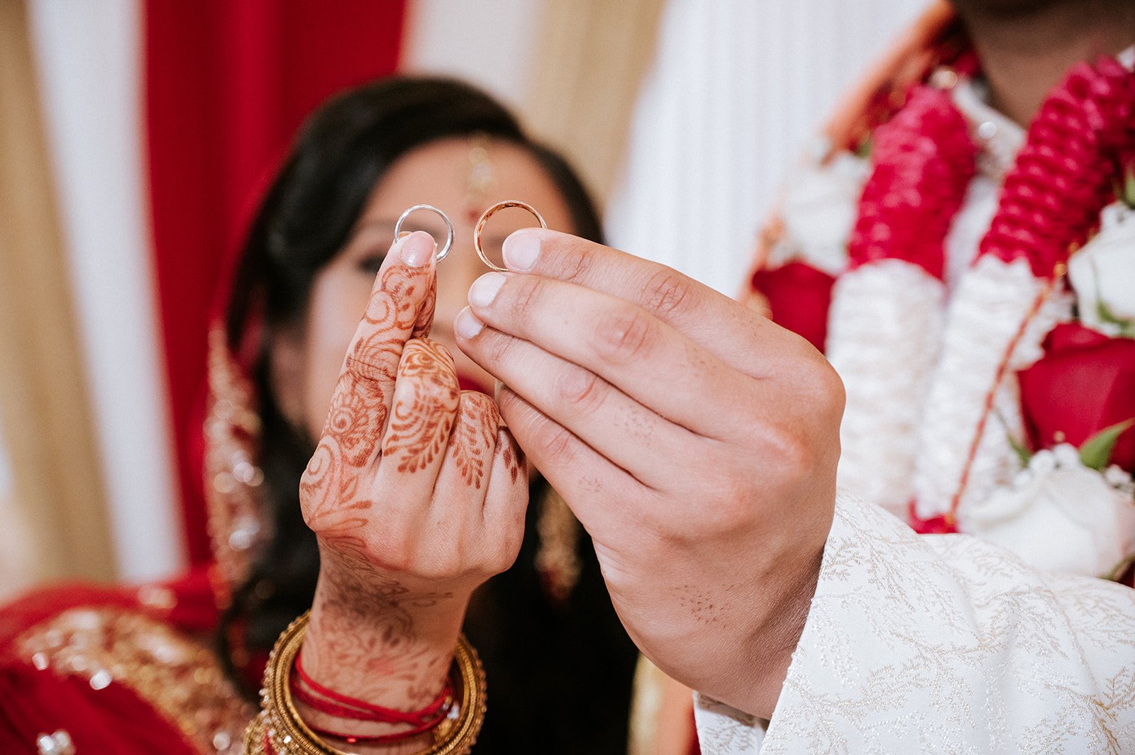 Bride and groom holding their wedding rings during a Hindu ceremony