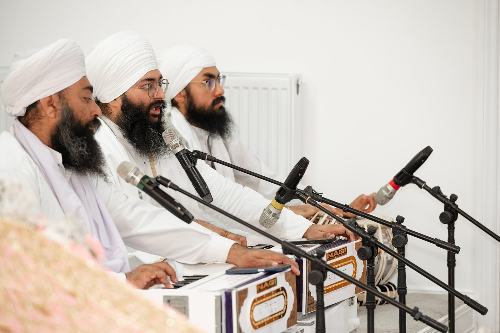 Sikh musicians singing and playing instruments during the wedding ceremony